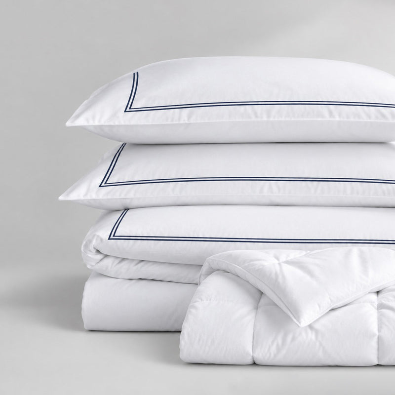 Bettwäsche-Set mit weißer Einziehdecke und dekorativer Randverarbeitung auf einem Bett