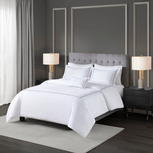 Bettwäsche-Set mit weißer Einziehdecke und dekorativer Randverarbeitung auf einem Bett
