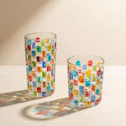 Transparentes Trinkglas mit bunter geometrischer Mosaikverzierung