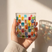 Transparentes Trinkglas mit bunter geometrischer Mosaikverzierung