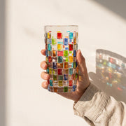 Transparentes Trinkglas mit bunter geometrischer Mosaikverzierung