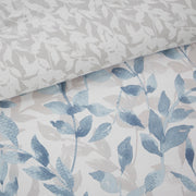Blaues 8-teiliges Bettwäsche-Set mit wendbarer Bettdecke und Blättermuster auf einem Bett