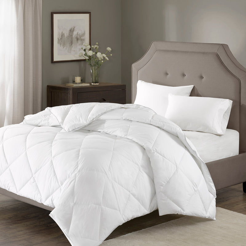 Weiße Steppdecke mit großer Rautensteppung auf einem Bett
