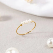 Filigraner goldfarbener Perlenring mit weißen Perlen