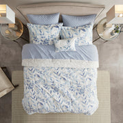 Blaues 8-teiliges Bettwäsche-Set mit wendbarer Bettdecke und Blättermuster auf einem Bett