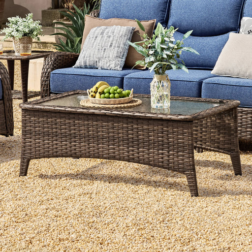 Brauner Rattan-Couchtisch mit transparenter Glasplatte im Außenbereich