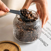 Transparentes strukturiertes Vorratsglas mit dunklem Holzdeckel