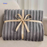 Weiche Plüschdecke mit ausgeprägter Rippstruktur auf Sofa und Sessel