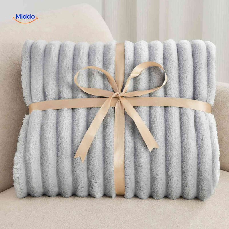 Weiche Plüschdecke mit ausgeprägter Rippstruktur auf Sofa und Sessel