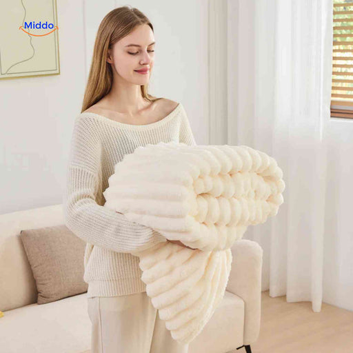 Weiche Plüschdecke mit ausgeprägter Rippstruktur auf Sofa und Sessel