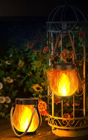 Schwarze Solarleuchte in Laternenform mit Seilgriff und leuchtendem Flammeneffekt im Garten