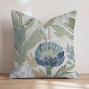 Blaues Dekokissen mit floralem Distelmotiv auf einem Sofa