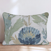 Blaues Dekokissen mit floralem Distelmotiv auf einem Sofa