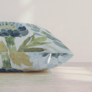 Blaues Dekokissen mit floralem Distelmotiv auf einem Sofa