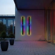 Lineare Außenwandleuchte mit schmalem, hochformatigem Leuchtkörper an einer modernen Fassade