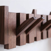 Wandgarderobe aus Holz mit mehreren klappbaren Haken in Brauntönen