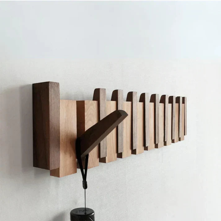 Wandgarderobe aus Holz mit mehreren klappbaren Haken in Brauntönen