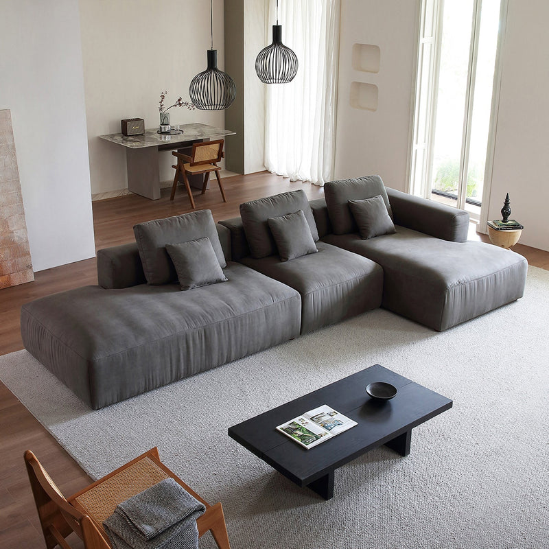 Modulares Ecksofa mit Ottomane, Rückenkissen und quadratischen Sofakissen