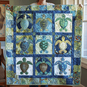 Quiltierte blaue Steppdecke mit farbigen Meeresschildkröten und dekorativem Ornamentrand