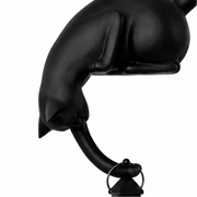 Katzenfigur mit leuchtender LED-Laterne an einer Regalkante