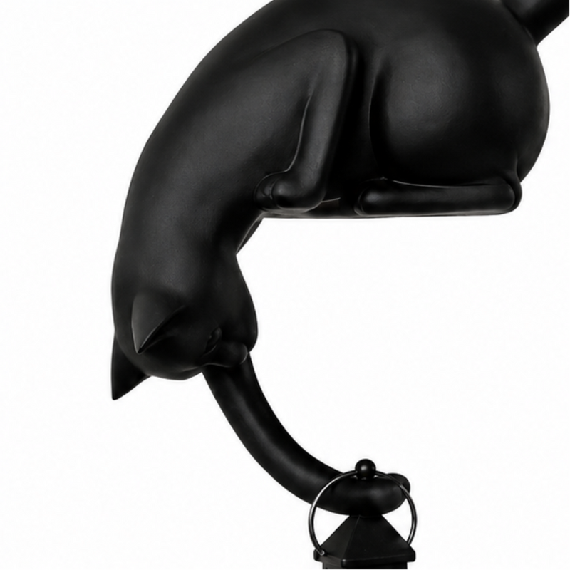Katzenfigur mit leuchtender LED-Laterne an einer Regalkante