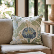 Blaues Dekokissen mit floralem Distelmotiv auf einem Sofa
