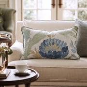 Blaues Dekokissen mit floralem Distelmotiv auf einem Sofa