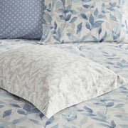 Blaues 8-teiliges Bettwäsche-Set mit wendbarer Bettdecke und Blättermuster auf einem Bett