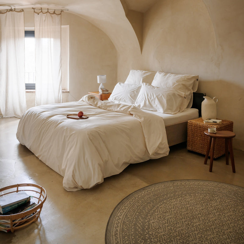 Cremefarbenes Bettwäsche-Set mit Bettbezug und Kissenbezügen auf einem Bett
