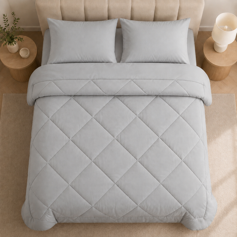 2-in-1 Bettdecke mit dekorativer Rautensteppung auf einem Bett
