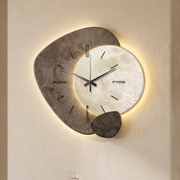Dekorative graue Wanduhr mit Mondmotiv und warmem Hintergrundlicht