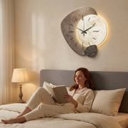 Dekorative graue Wanduhr mit Mondmotiv und warmem Hintergrundlicht
