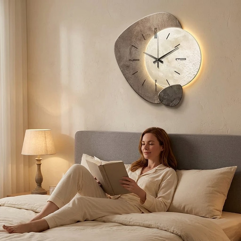 Dekorative graue Wanduhr mit Mondmotiv und warmem Hintergrundlicht