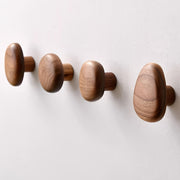 Abgerundete Wandhaken aus Holz an einer hellen Wand