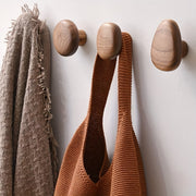 Abgerundete Wandhaken aus Holz an einer hellen Wand