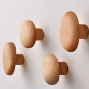 Abgerundete Wandhaken aus Holz an einer hellen Wand