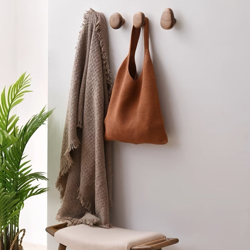Abgerundete Wandhaken aus Holz an einer hellen Wand
