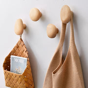 Abgerundete Wandhaken aus Holz an einer hellen Wand