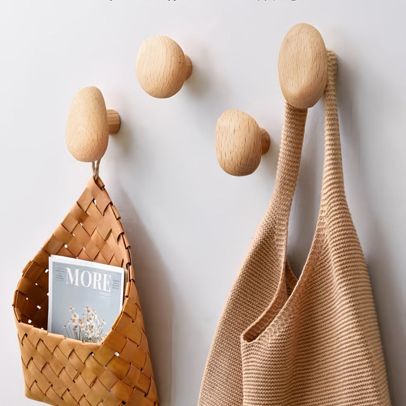 Abgerundete Wandhaken aus Holz an einer hellen Wand