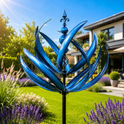 Dekoratives Windspiel in Blumenform mit geschwungenen Elementen und langem Stab im Garten
